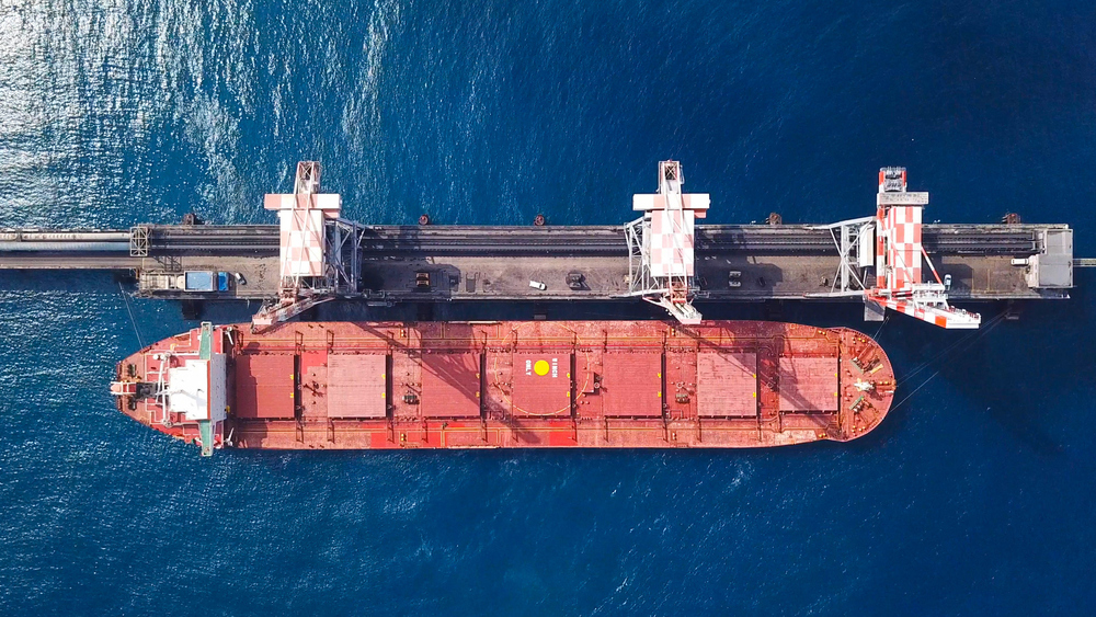 A top down view of a ship alongside a jetty